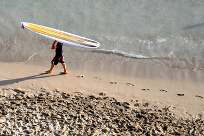 Full length of man surfing on beach