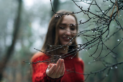 Improving mental wellbeing, relax and reduce stress. young woman in red sweater touching water