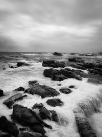 Scenic view of rocks in sea against sky