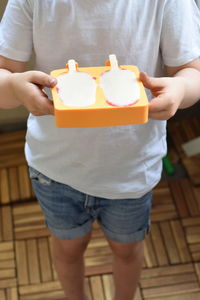 Close-up of a boy holding ice creams in molds