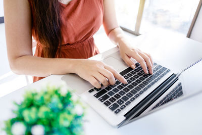 Midsection of woman using laptop