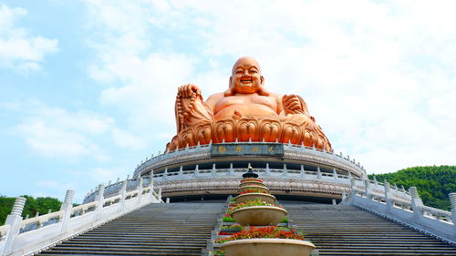 Low angle view of statue of temple against cloudy sky