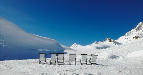 Scenic view of snowcapped mountains against clear blue sky