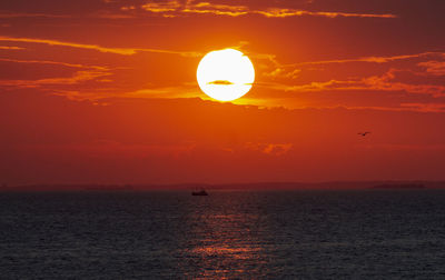 Scenic view of sea against orange sky