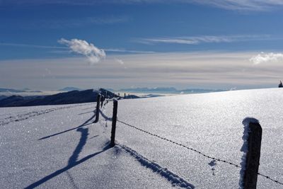 Scenic view of snow covered land against sky