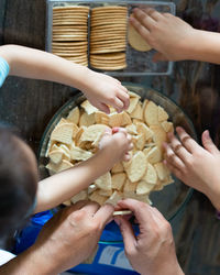 Hands making malaysian triple chocolate dessert.  crushing the cookies into tiny pieces.