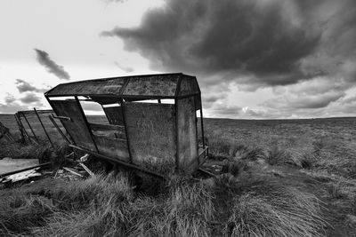 Abandoned built structure on field against sky