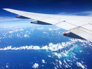 Airplane wing flying over clouds