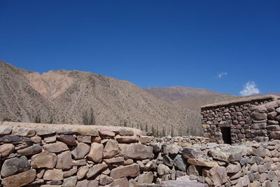 Stone wall against clear blue sky