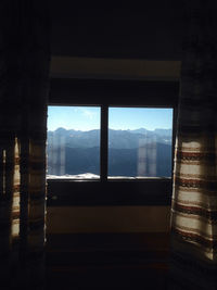 Close-up of silhouette trees against sky seen through window