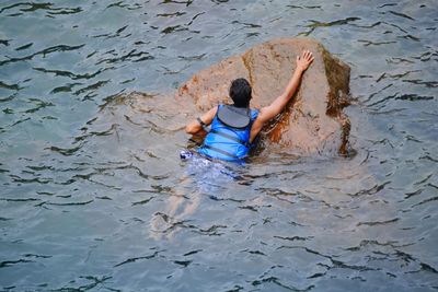 Rear view of man swimming in water