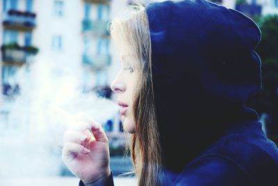 Portrait of young woman smoking cigarette