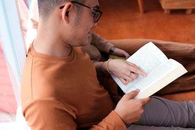 Midsection of young woman reading book