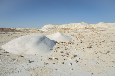 Scenic view of arid landscape against clear blue sky