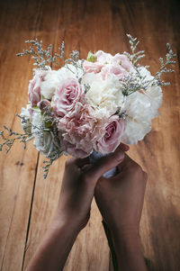 Cropped hands of woman holding bouquet