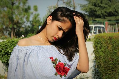 Close-up of a beautiful young woman with red flower