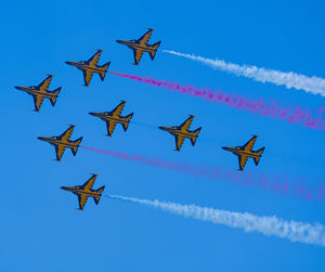 Low angle view of airshow against blue sky