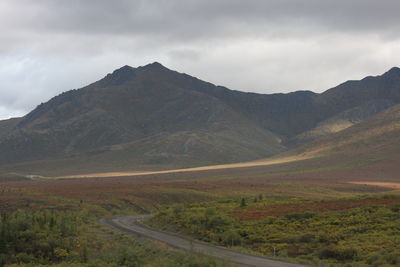 Scenic view of road amidst mountains against sky