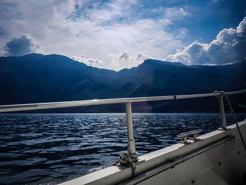 Scenic view of sea by mountains against sky