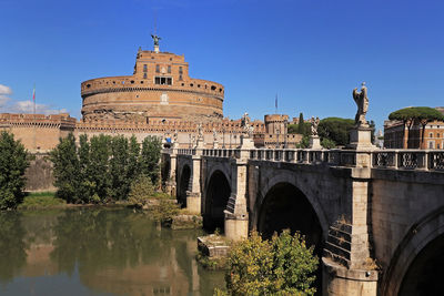 Arch bridge over river against sky