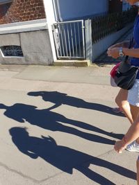 Shadow of woman walking on footpath