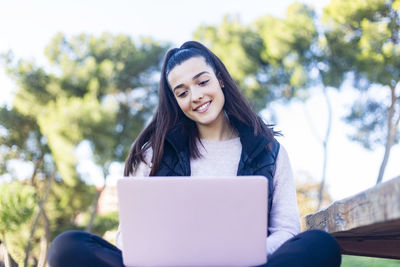 Portrait of a smiling young woman using mobile phone