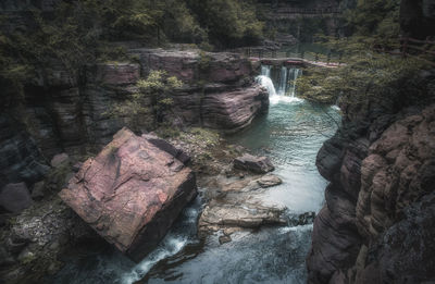 High angle view of waterfall amidst rocks in forest