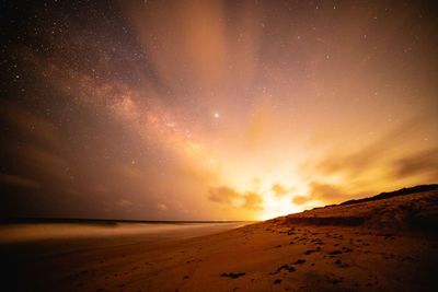 Scenic view of beach against sky at night