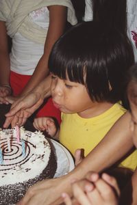 Cute girl blowing cake candles at home