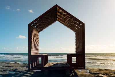 Lifeguard hut on beach against sky