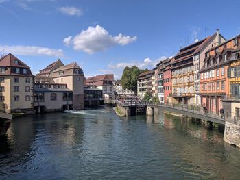 River amidst buildings in town against sky