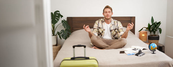 Portrait of young woman sitting on sofa at home