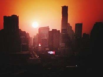 Silhouette buildings against sky during sunset