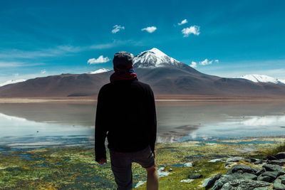 Rear view of woman standing on mountain against sky