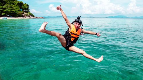 Man jumping in sea against sky