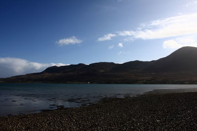 Scenic view of sea and mountains against sky