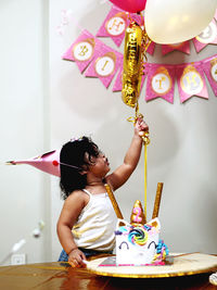 Full length of a girl holding multi colored umbrella