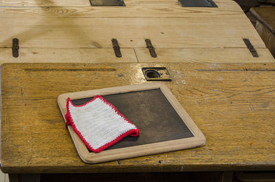 High angle view of blackboard and knitted wool on table