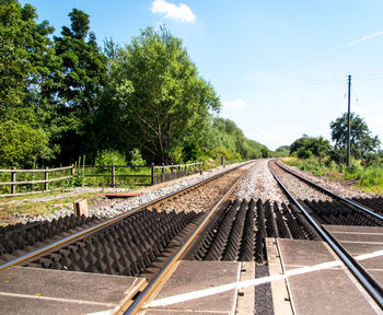 Railroad tracks against sky on sunny day