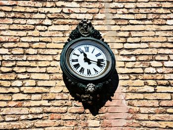 Low angle view of clock on brick wall