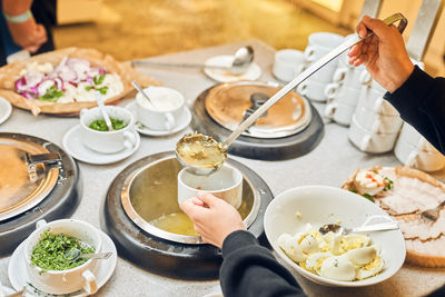 Cropped hand of man preparing food on table