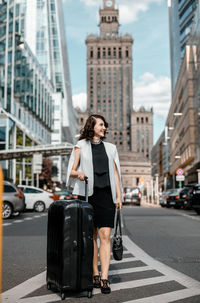 Full length of young woman on road in city