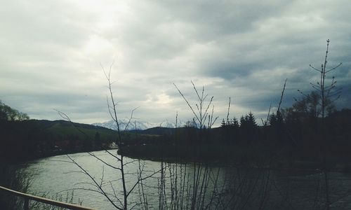 Scenic shot of calm lake against cloudy sky