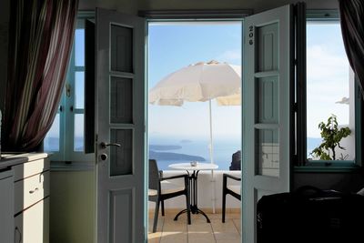 Table and chairs arranged in balcony against sky