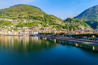 Scenic view of town by mountain against sky