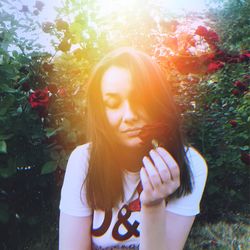 Portrait of smiling woman standing against trees