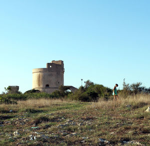 Side view of woman on field against clear sky