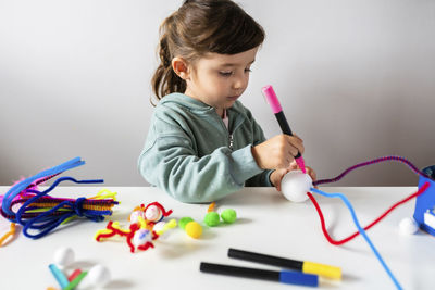 Cute boy holding toy toys on table