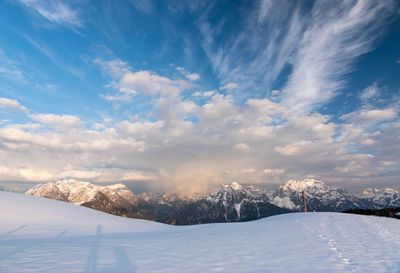 Snow covered landscape against sky