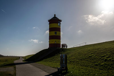 Lighthouse by sea against sky